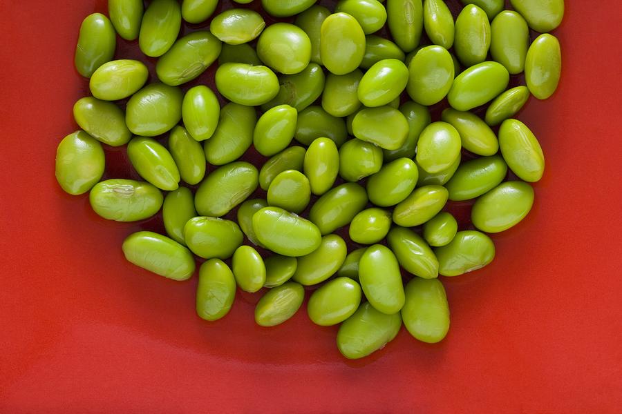 Closeup of lima beans with red background Photograph by Rubberball/Mike Kemp