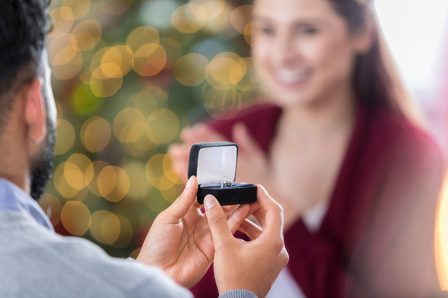 Closeup of ring box as young man proposes to girlfriend Photograph by SDI Productions