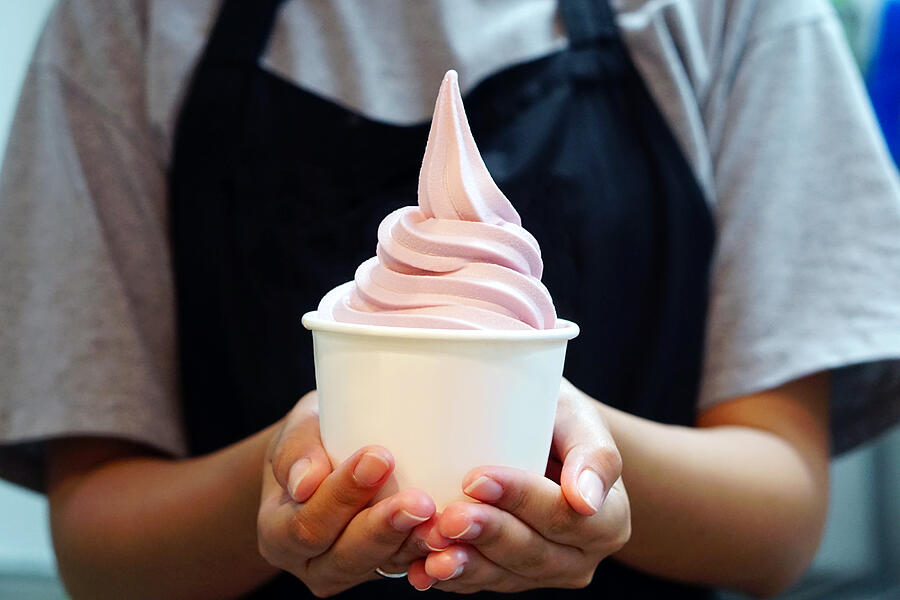 Closeup of woman s hand holding takeaway cup with organic frozen yogurt ice cream, Its delicious and healthy enjoy eating concept. Photograph by Food Photographer