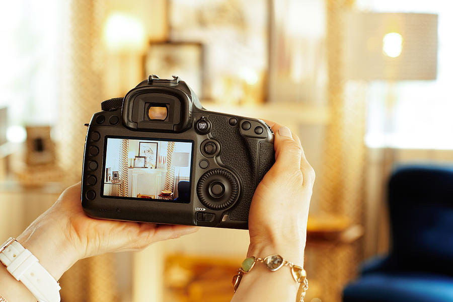 Closeup on DSLR camera in hand of female interior photographer Photograph by CentralITAlliance