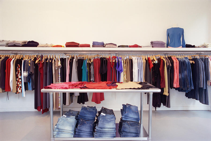 Clothes on rack and table in store Photograph by John A. Rizzo