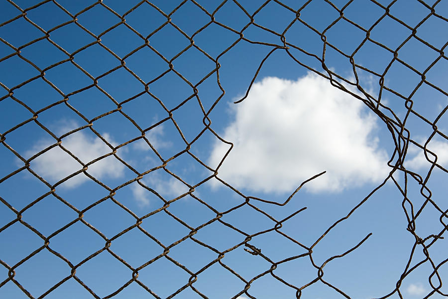 Cloud through a broken fence Photograph by Image Source