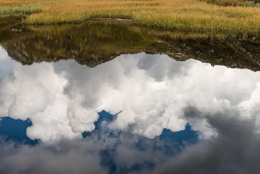 Clouds and mountains reflecting in mountain lake Photograph by Nicolo Sertorio