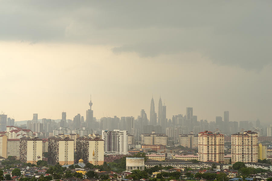 Cloudy moments of downtown Kuala Lumpur with Petronas Twin Towers and KL Tower dominant the skyline. Photograph by Shaifulzamri
