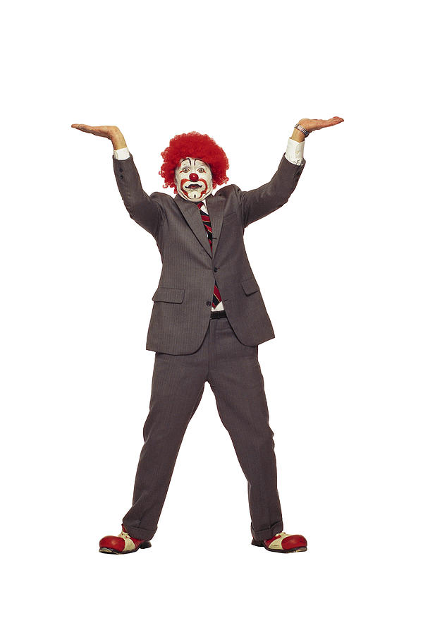 Clown in business suit lifting Photograph by Comstock