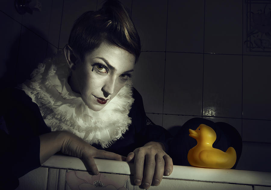 Clown with rubber duck comming out of bath tube Photograph by Pawel Wewiorski