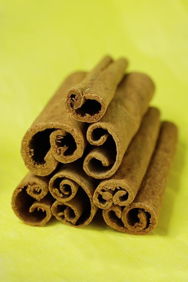 Cinnamon Photograph - Cluster of Brown Cinnamon Sticks on Yellow by Iris Richardson