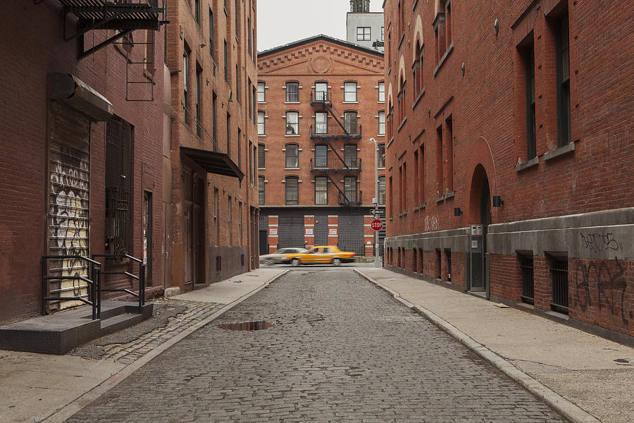 cobblestone Alley in tribeca with taxi passing by Photograph by Erik Von Weber