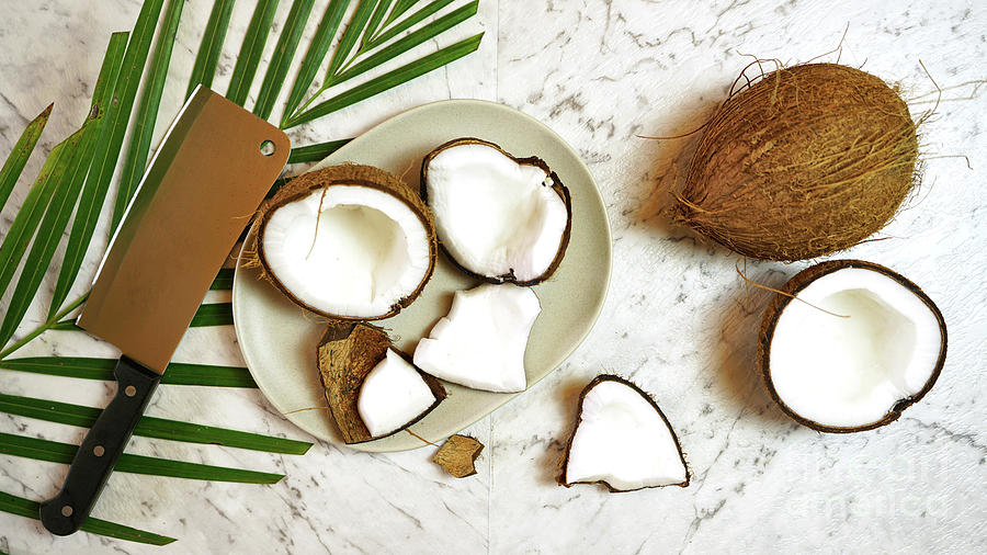 Nature Photograph - Coconut cut into pieces on plate on marble table top, creative flat lay. by Milleflore Images