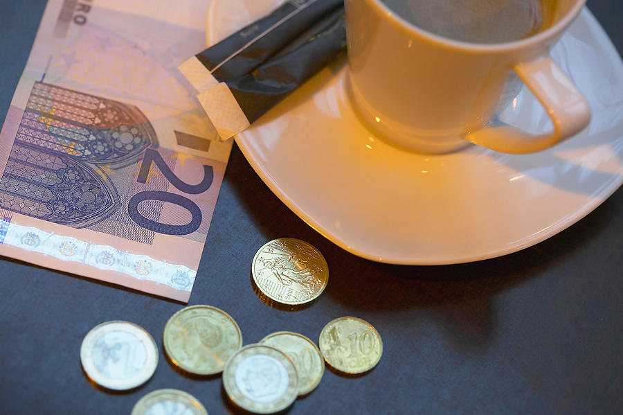 Coffee and money on table Photograph by Pnc