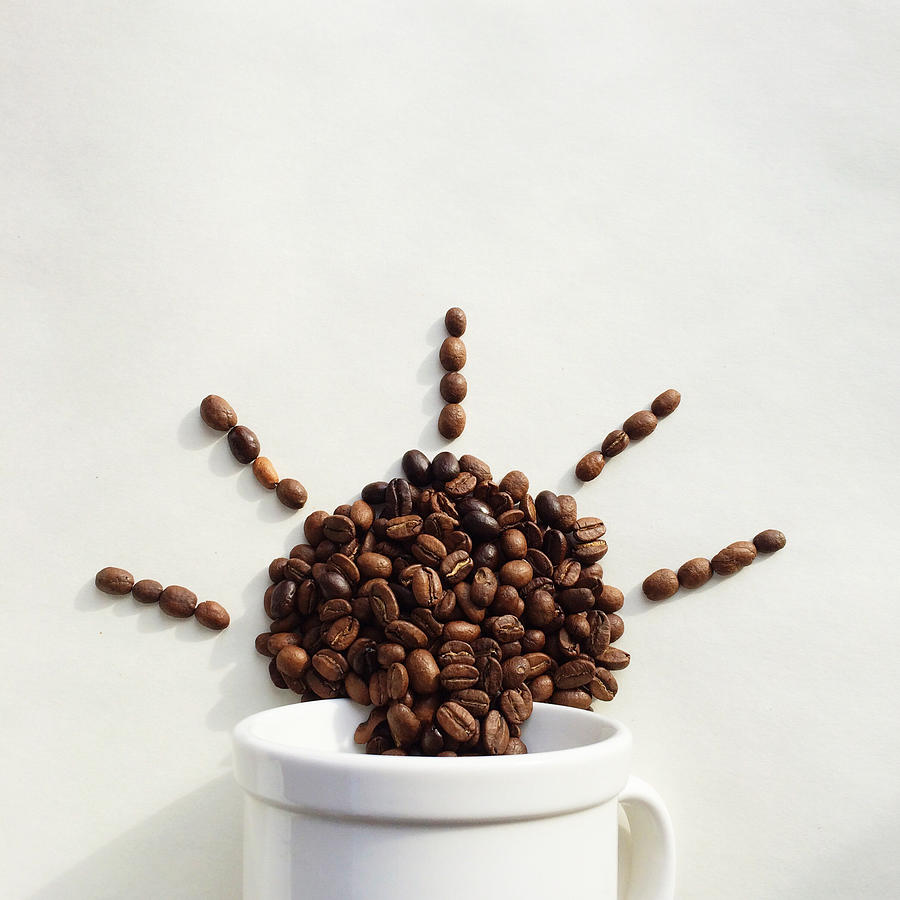 Coffee beans coming out of a cup in the shape of the sun Photograph by Denistorm