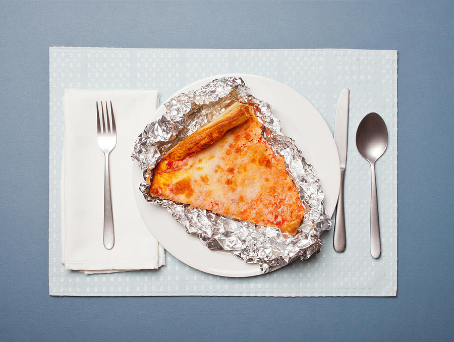 Cold, leftover pizza in foil on a plate Photograph by William Andrew
