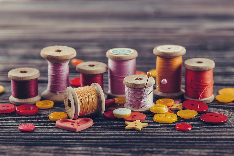 Collection of spools threads in yellow-pink colors Photograph by Oxygen