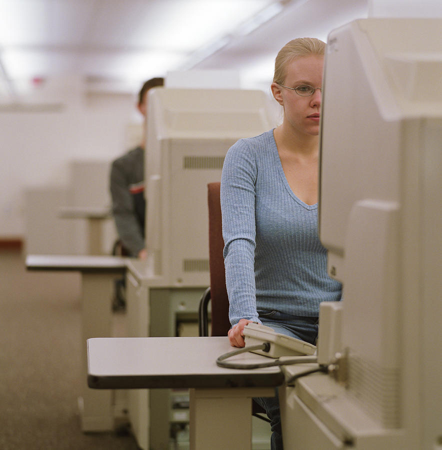 College student using microfilm machine in library Photograph by Pnc