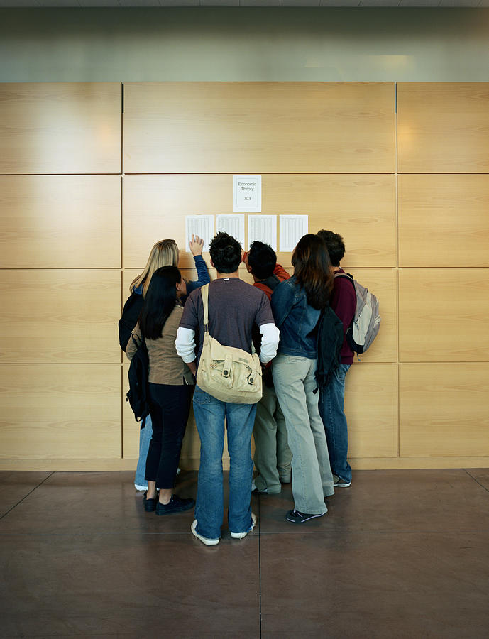 College students checking grades posted on wall Photograph by Stephen Simpson