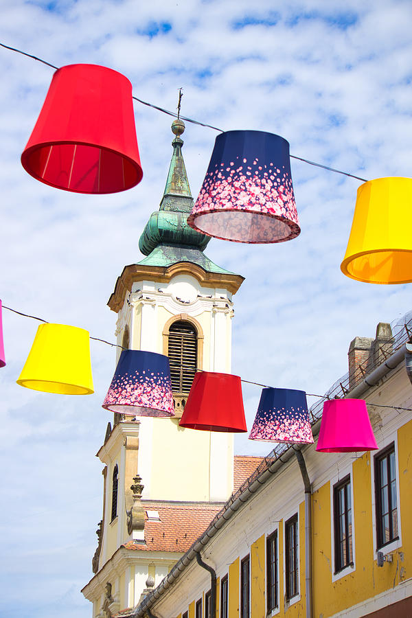 Colorful lampshades hanging in front of a church Photograph by ...