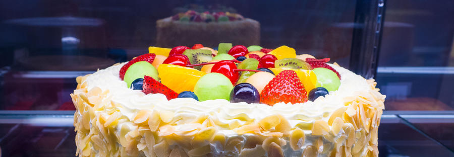 Colorful mixed fruit fresh cream cake in refrigerator showcase Photograph by Lollynut