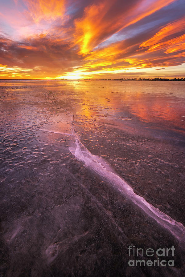 Colorful Sunrise on the Frozen Lake with ice cracks glowing Photograph by Ronda Kimbrow