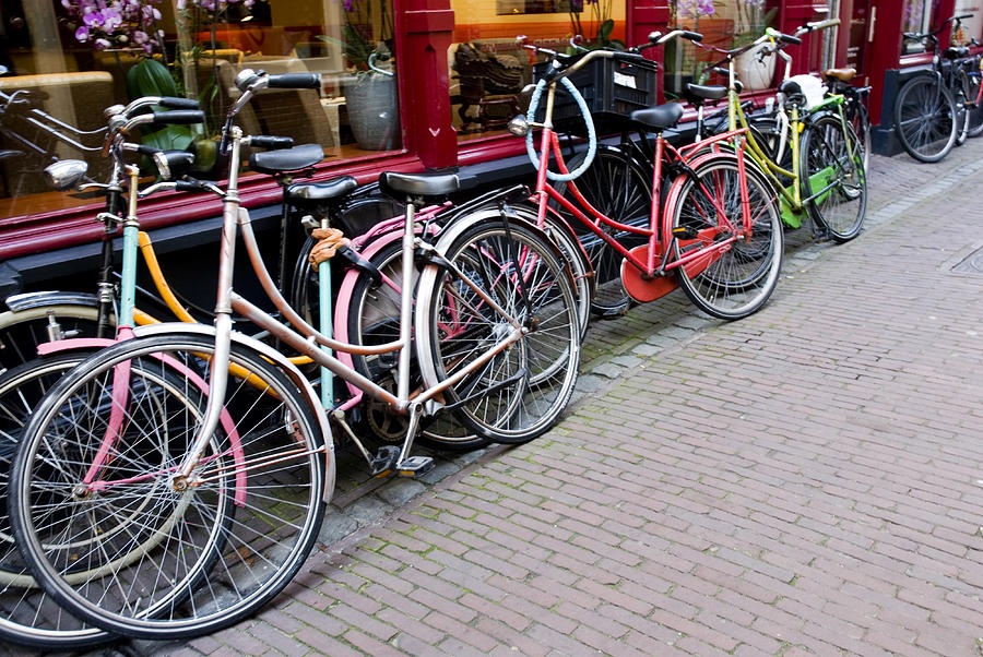 Coloured bicycles parked outside shop Photograph by Lyn Holly Coorg