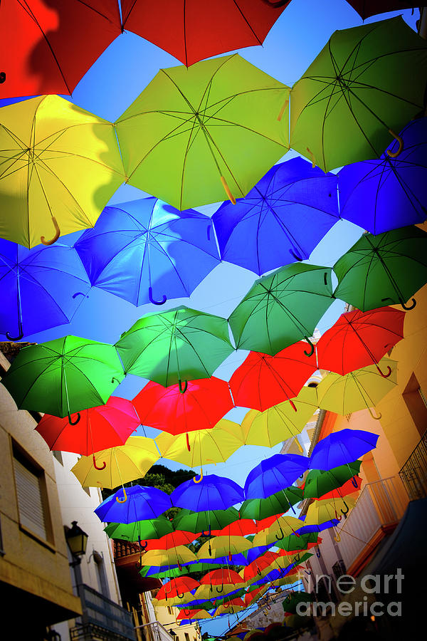 Colourful Umbrellas over streets in Spanish Village during Fiesta Photograph by Peter Noyce