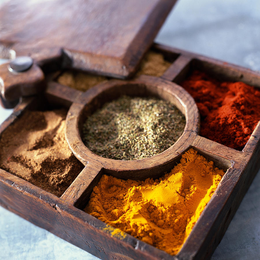 Compartmented wooden box with various spices Photograph by Jean-Blaise Hall