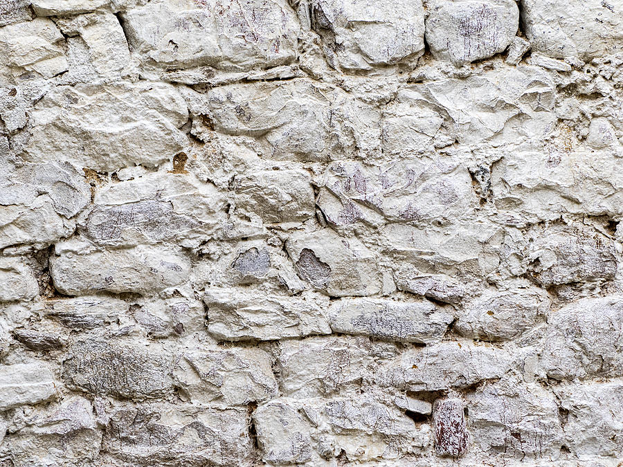Complete setting of a facade of a cement wall with stones of white colors, ancient and spoil in the time Photograph by Jose A. Bernat Bacete
