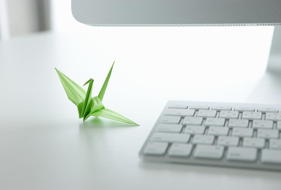 Computer with green paper crane  Photograph by Sot