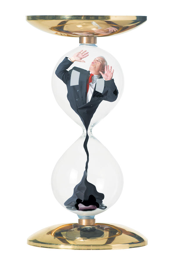 Conceptual Photo Of A Caucasian Business Man In A Suit As He Is Stuck In And Sucked Through An Hourglass Photograph by Photodisc