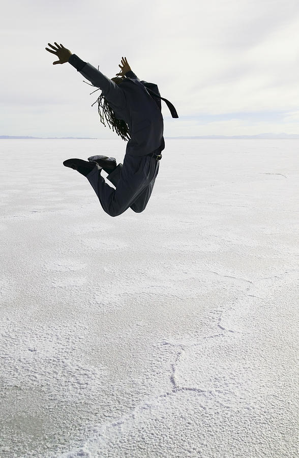 Conceptual Shot Of A Young Adult Male As He Jumps Through The Air In The Middle Of A Desert Photograph by Photodisc