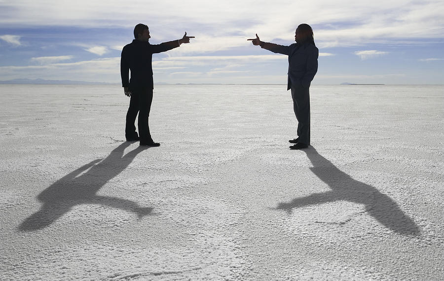 Conceptual Shot Of Two Business People As They Stand In An Open Desert And Point At Each Other Photograph by Photodisc