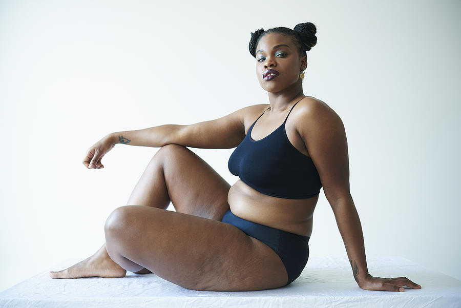 Confident Curvy Woman Sitting And Looking To Camera Photograph by Tara Moore