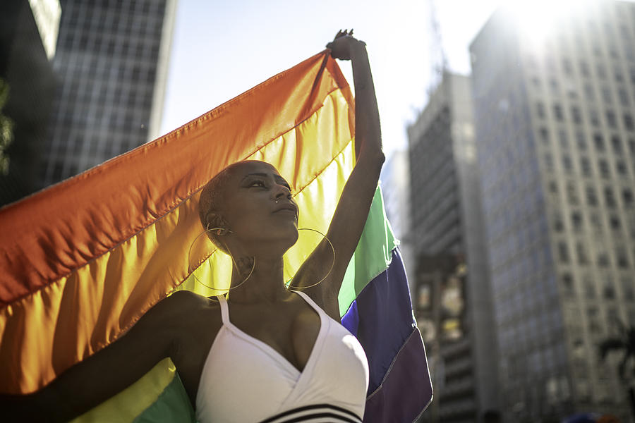 Confident lesbian woman holding rainbow flag during pride parade Photograph by FG Trade