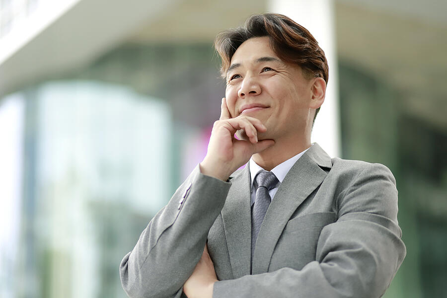 Confident middle aged businessman looking away outdoors Photograph by Runstudio