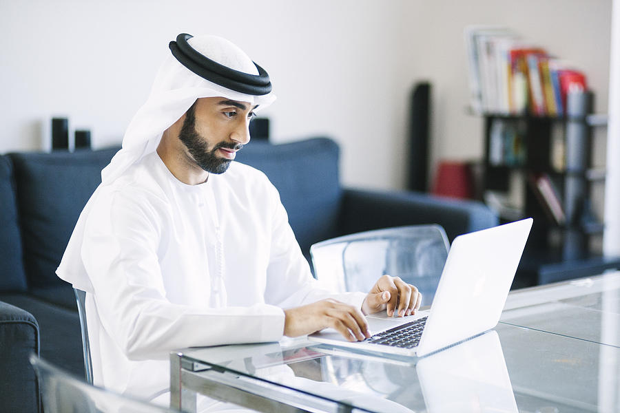 Content Arab Man Using Laptop at Home Photograph by Visualspace