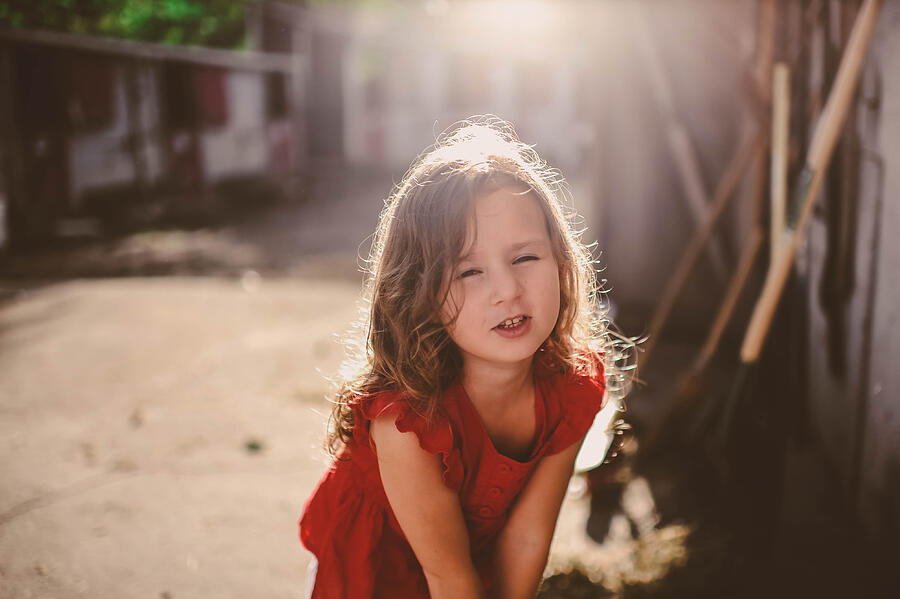 Content. Little girl, cute face at a farm. Photograph by Essential Life Photography