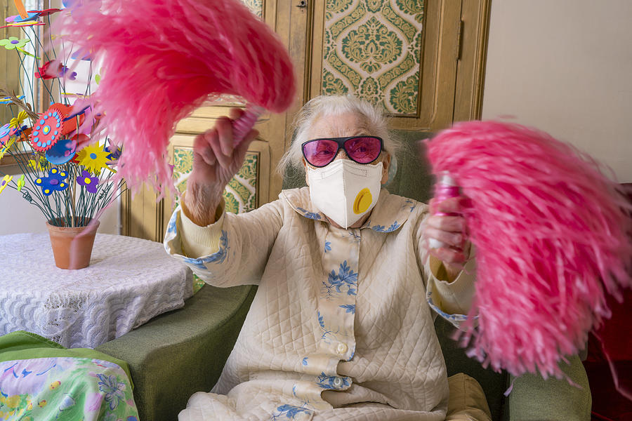 Coronavirus COVID-19 pandemic confinement with mask an humor Cheerleader pom-pom elderly woman happy Photograph by Mediterranean