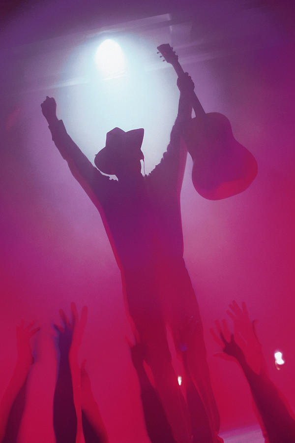 Country musician on stage at concert Photograph by Comstock