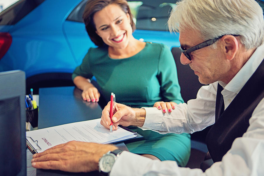 Couple buying new car and signing the contract Photograph by Praetorianphoto