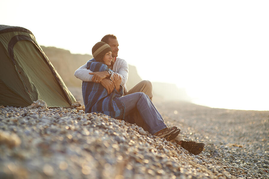 Couple embracing outside tent on beach. Photograph by Mike Harrington