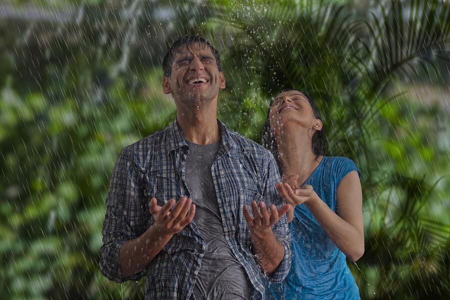 Couple enjoying in the rain Photograph by IndiaPix/IndiaPicture