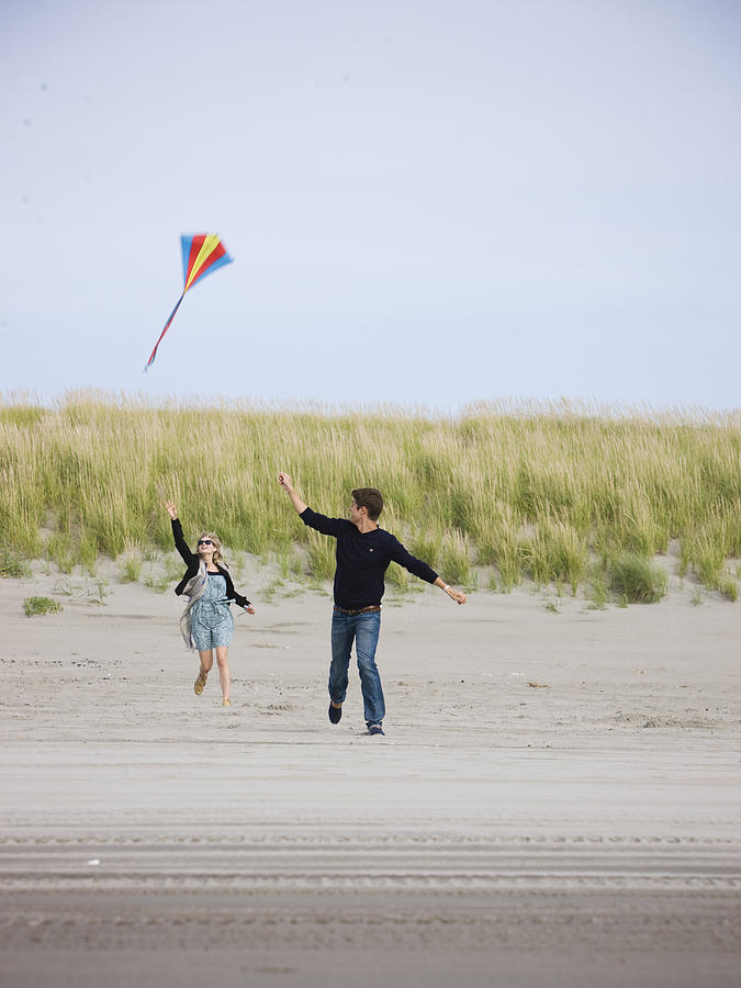 Couple Flying A Kite At The Beach Photograph by Nicole Hill