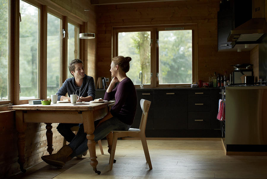 Couple having breakfast at table in cottage Photograph by Morsa Images