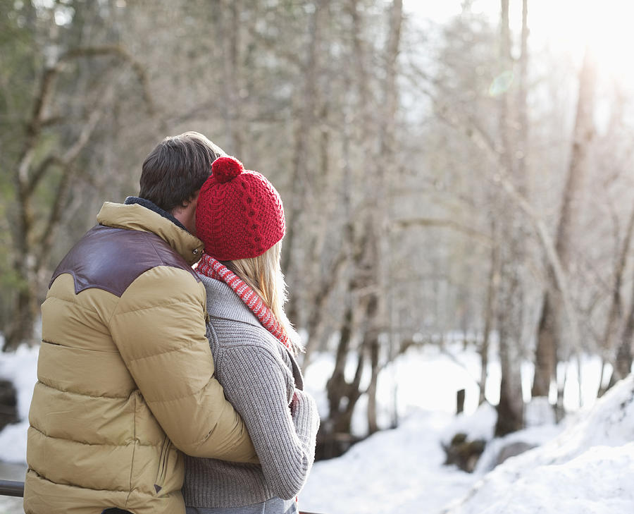 Couple hugging in snowy woods Photograph by Tom Merton