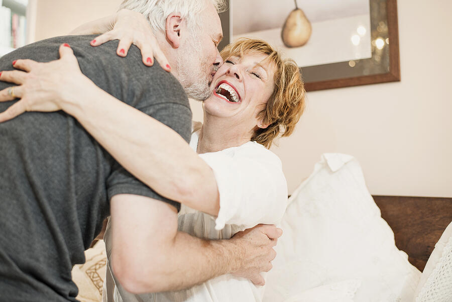 Couple hugging, mature woman laughing Photograph by Redheadpictures