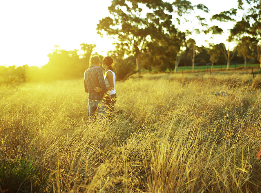 Couple in field of tall grass, rear view Photograph by Sanna Lindberg