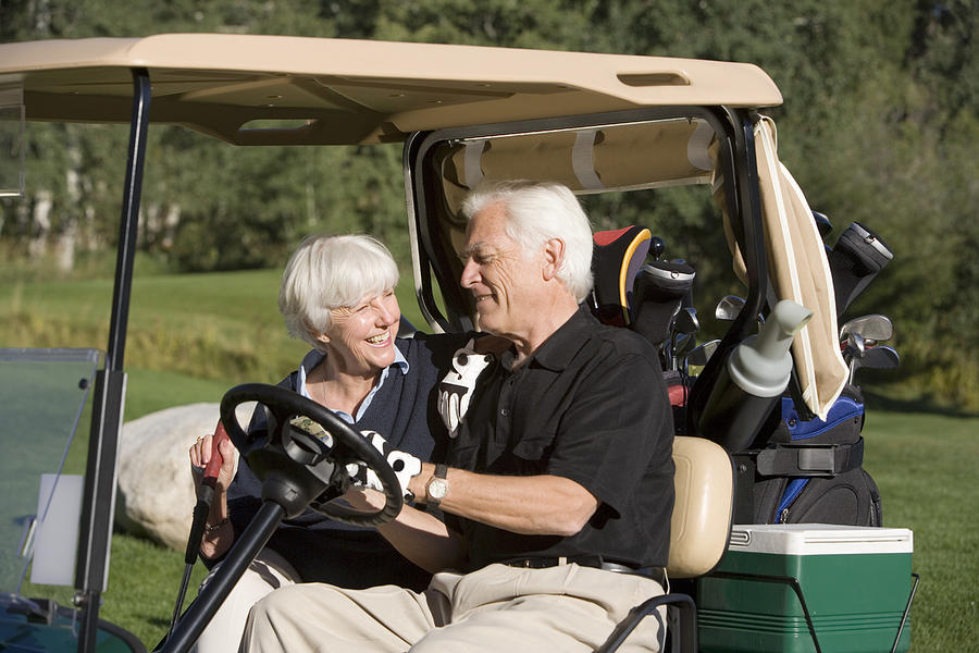 Couple in golf cart Photograph by Comstock Images