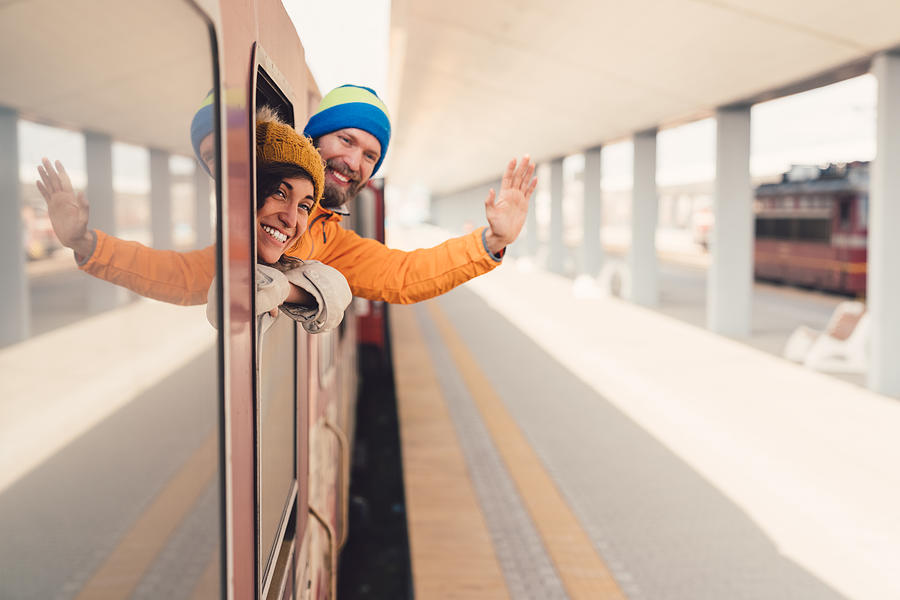 Couple in train waving for goodbye Photograph by Martin-dm