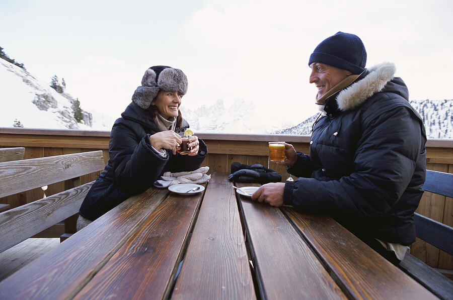 Couple in Warm Outfits Sitting Outdoors Having a Drink Photograph by Michelangelo Gratton