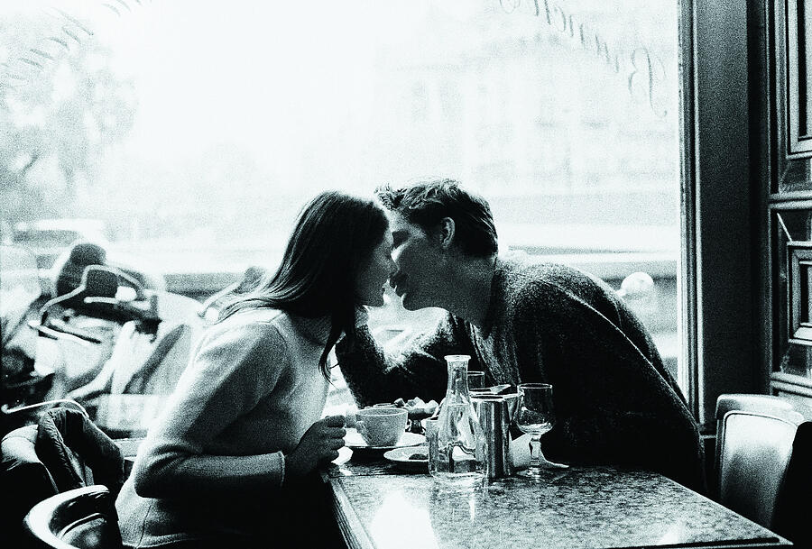 Couple kissing over coffee Photograph by Photodisc