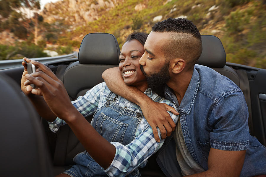 Couple kissing while making selfie in car Photograph by Klaus Vedfelt